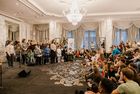 Im Vordergrund singt eine Schülerin ein Lied. Im Hintergrund sieht man den Schülerchor